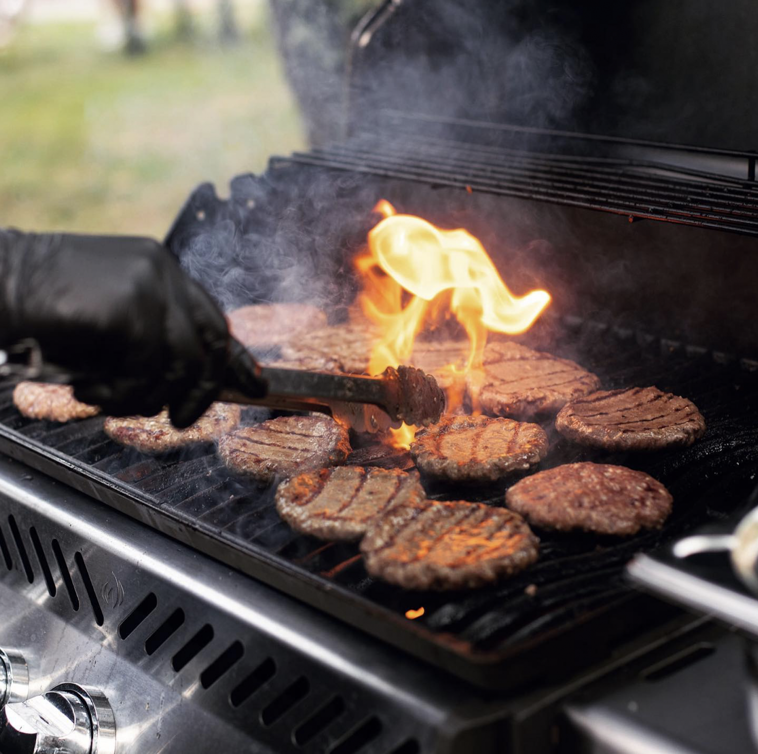 Grill Catering Frankfurt mit Grillmeister von GOOSE Gourmet, der Burger und Fleisch grillt.
