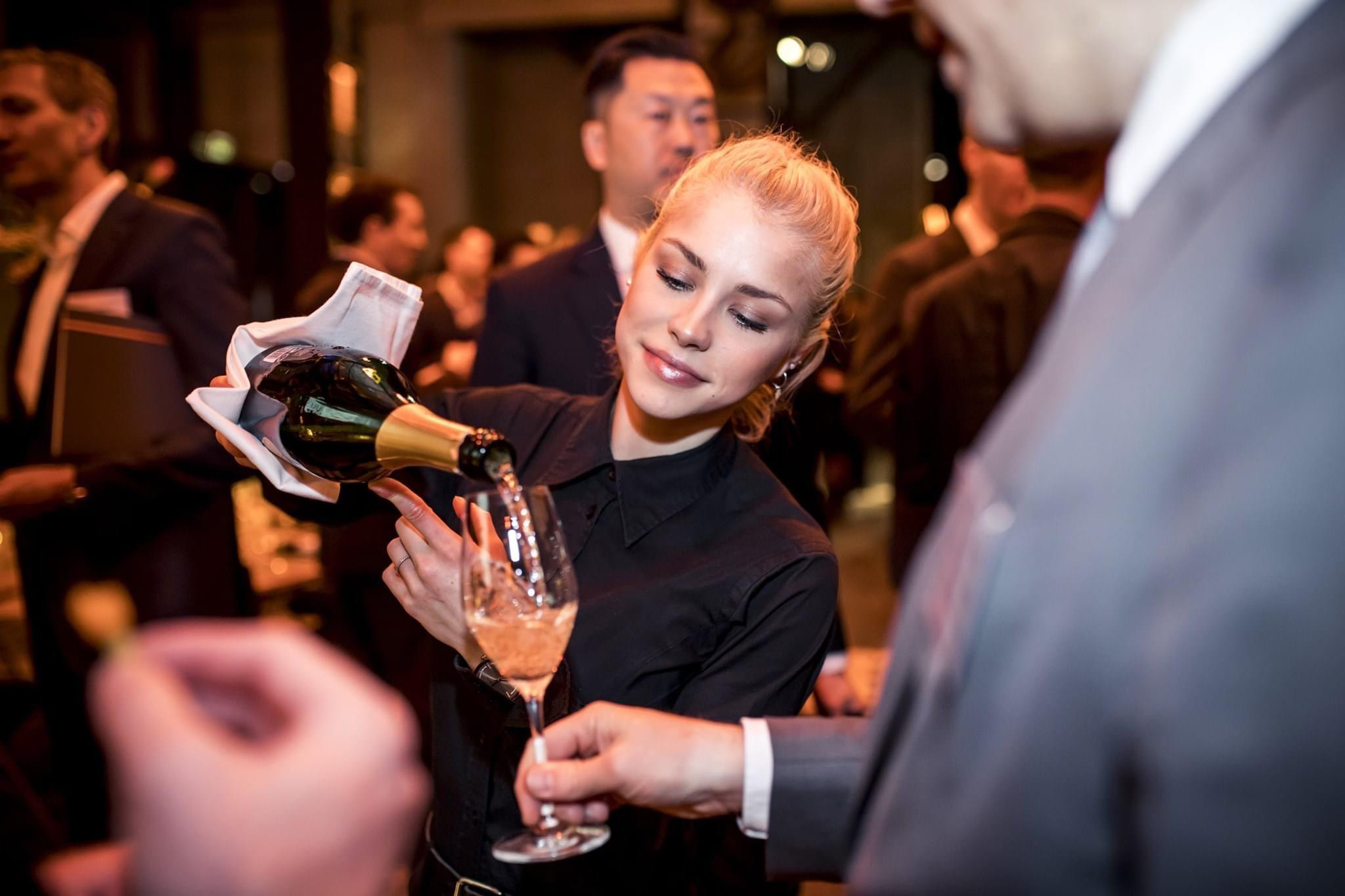 a smiling service staff at a catering by goose gourmet in frankfurt