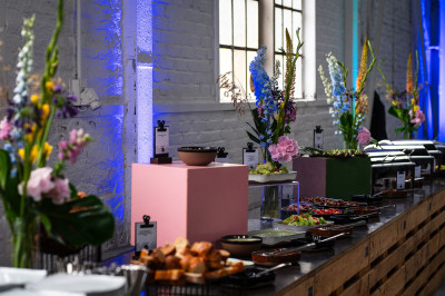 Buntes Cateringbuffet mit diversen Speisen und Blumendekoration